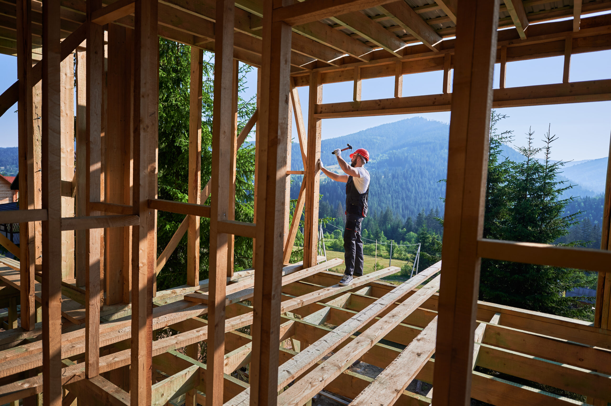 Construction worker building a residential home frame in the mountains – symbolizing Cascara Capital’s new construction financing solutions