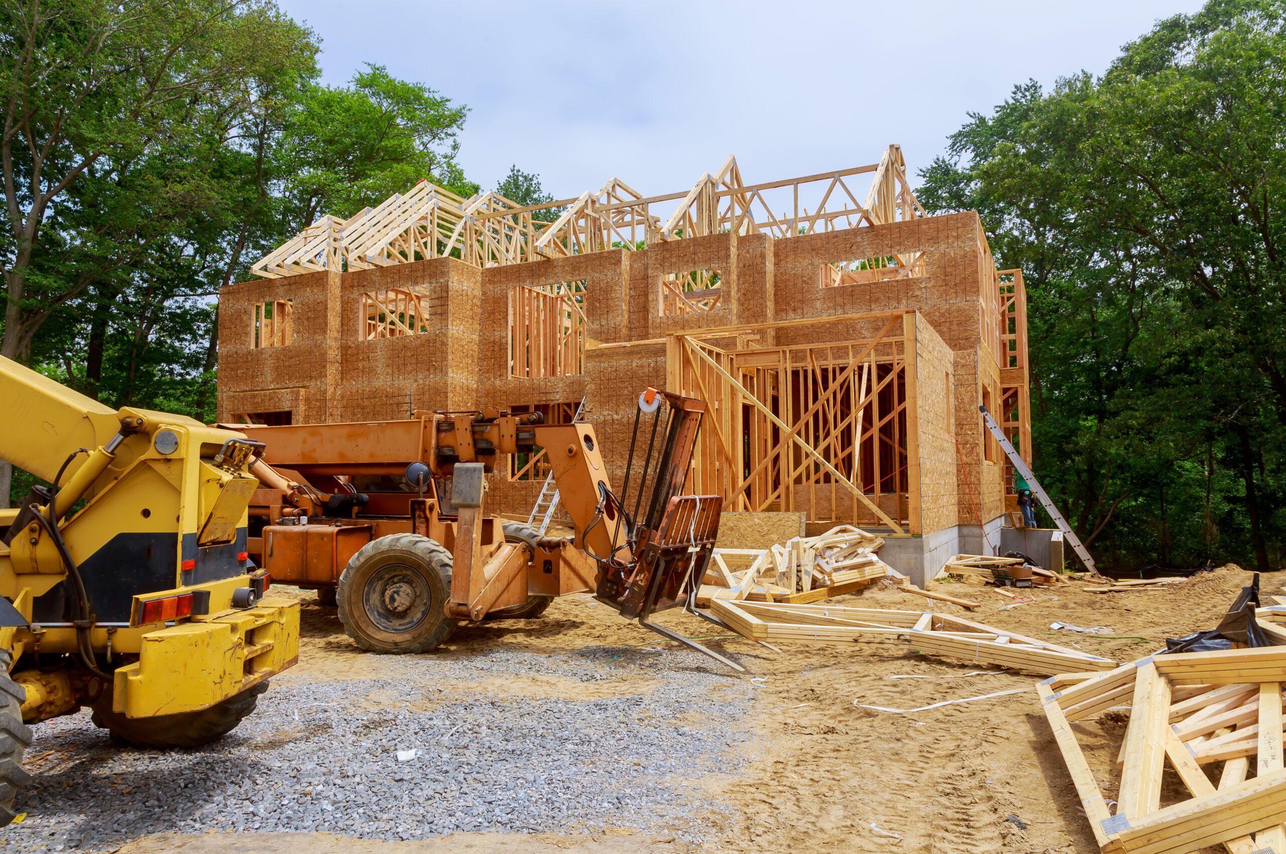 Framed residential home under construction with heavy equipment on site – representing Cascara Capital’s vertical construction loan offerings.